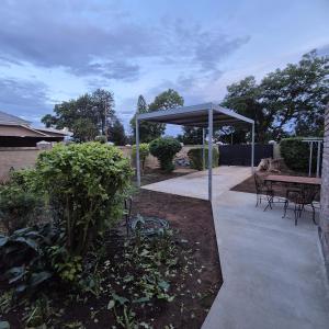 a pavilion with a table and chairs in a garden at 05 on Mc Donald in Kirkwood