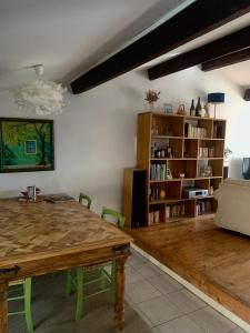 a living room with a wooden table and a book shelf at Les Toits d'Aniane in Aniane