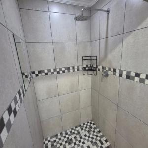 a shower with a black and white checkered floor at 05 on Mc Donald in Kirkwood +4 photos