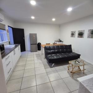 a living room with a black couch and a kitchen at 05 on Mc Donald in Kirkwood