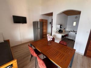 a kitchen and dining room with a wooden table and chairs at Résidence Punta paliagi in Calcatoggio