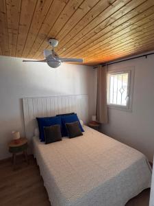 a bedroom with a bed with blue pillows and a ceiling at Résidence Punta paliagi in Calcatoggio