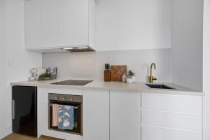 a kitchen with white cabinets and a sink and a stove at Sunset Hideaway in Marino in Marino