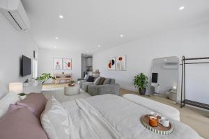 a white living room with a large white couch at Sunset Hideaway in Marino in Marino