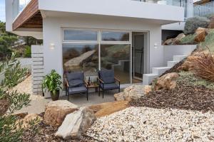 two chairs in front of a house with rocks at Sunset Hideaway in Marino in Marino