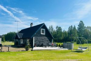 a log cabin with a playground and a swing at Villa Nõva külalistemaja saunaga in Vaisi