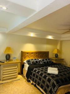 a bedroom with a bed with two night stands and two lamps at Hotel Vagabundo in Tijuana