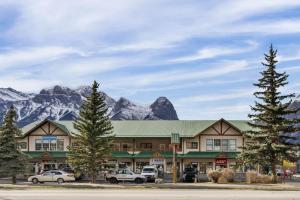 a large building with mountains in the background at Spacious 1 Bed with Mountain Views only steps from Downtown in Canmore