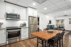 a kitchen and dining room with a wooden table and appliances at Spacious 1 Bed with Mountain Views only steps from Downtown in Canmore