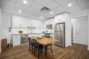 a kitchen with white cabinets and a wooden table and chairs at Spacious 1 Bed with Mountain Views only steps from Downtown in Canmore +23 photos