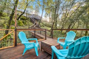 three blue chairs sitting on a wooden deck with trees at Phoenix Lake Sonora in Sonora