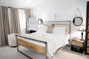 a bedroom with a large white bed and two mirrors at Amalfi Surf Lodge in ChiltiupÃ¡n +65 photos