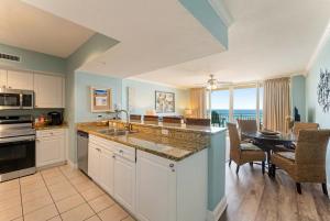 a kitchen and dining room with a view of the ocean at Goin Coastal Emerald Beach Unit 729 in Panama City Beach