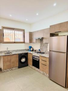 a kitchen with a stainless steel refrigerator and a dishwasher at SOHO Rooftop 360 Sunset Edition in Essaouira