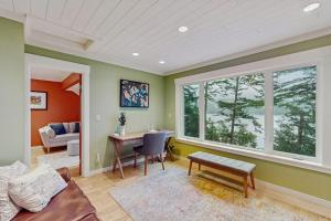 a living room with green walls and a table and chairs at Shore Thing Retreat in Eastsound