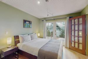 a bedroom with a bed and a large window at Shore Thing Retreat in Eastsound