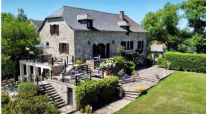 an old stone house with chairs and a yard at Soulages in Najac