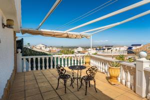 a patio with a table and chairs on a balcony at Enjoy complete seclusion at Casa Delfin, featuring your own stunning private pool and sunset views in Gran Alacant