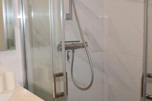 a shower with a glass door in a bathroom at Maison de Gilydie in Chabris