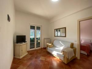 a living room with a white couch and a television at Portico in Moneglia