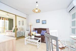 a living room with a couch and a table at ADELFAS - Fincas Arena in Benidorm