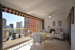 a room with a balcony with a table and chairs at ADELFAS - Fincas Arena in Benidorm