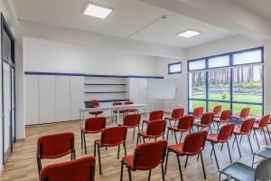 an empty classroom with red chairs and a white table at HI Ovar - Pousada de Juventude in Ovar +41 photos