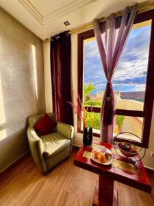 a living room with a chair and a table and a window at Ksar Sultan Dades - Dades Valley Retreat in Boumalne Dades