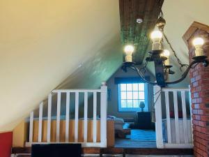a attic room with a bed and a chandelier at Villa Nõva külalistemaja saunaga in Vaisi