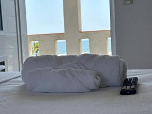 a white couch with a remote control on a bed at Casa paraíso escondido in Coyote +2 photos