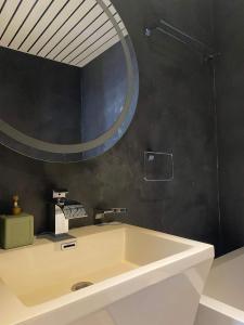 a bathroom with a white sink and a mirror at Hotel Le Terminus in Mons