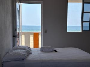 a bed in a bedroom with a view of the ocean at Casa paraíso escondido in Coyote