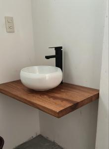 a bathroom with a white sink on a wooden shelf at Casa paraíso escondido in Coyote