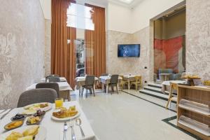 a dining room with a table with food on it at Hotel Giulia in Durrës