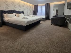a hotel room with a bed and a chair at Hillcrest Panorama Valea Prahovei in Poiana Comarnic