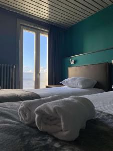 a bedroom with a bed with a large window at Hotel Le Terminus in Mons