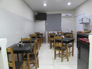 a dining room with tables and chairs in a restaurant at Hotel Minho SP - Melhor Opção do Centro - Café da Manhã Incluso - Perto do Metrô, 25 de Março e Brás - 10 Min do Allianz Parque, 11 Min do Expo Center Norte e 9 Min do Distrito Anhembi in São Paulo