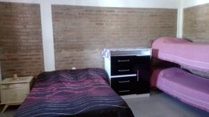 a bedroom with two beds and a dresser in it at Departamento Stella in Mina Clavero