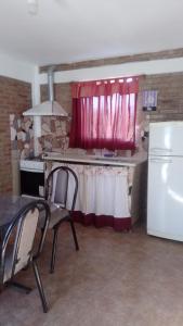 a kitchen with a table and two chairs and a refrigerator at Departamento Stella in Mina Clavero