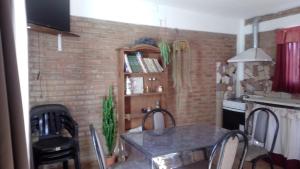 a table and chairs in a kitchen with a brick wall at Departamento Stella in Mina Clavero