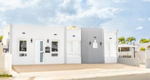 a white building with white doors and windows at AQUA Casa A-8 - Vibrant & FUN 3 BR House with Pool in Dorado