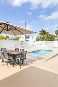 a patio with a table and chairs and a pool at AQUA Casa A-8 - Vibrant & FUN 3 BR House with Pool in Dorado