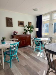 a dining room with two tables and blue chairs at Sävsjöns Gästgård in Hällefors