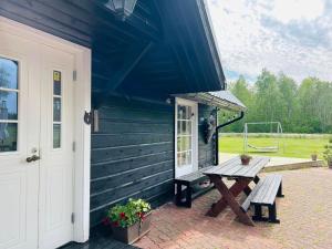 a picnic table outside of a house with a porch at Villa Nõva külalistemaja saunaga in Vaisi +7 photos