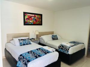 a hotel room with two beds and a painting on the wall at Mar de Indias House in Cartagena de Indias