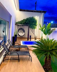 a living room with chairs and a potted plant at Studio Aeroporto in Teresina