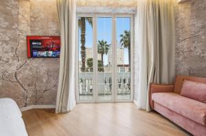 a living room with a couch and a large window at Hotel Giulia in Durrës