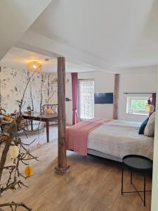 a bedroom with a bed and a table in it at Kade10Buren in Buren