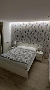 a bedroom with a bed with a stone wall at Apartments Ostanek 2 in Portorož