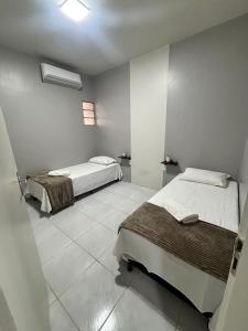 a bedroom with two beds and a tiled floor at Residencial Junino do Mestre - Casa 66 in Caruaru